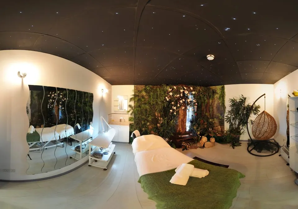 Treatment room with leafy wall decor and hanging chair at CoLaz Hounslow