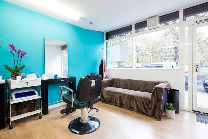 Essential Beautyworks front room with turquoise walls, styling chair and waiting sofa