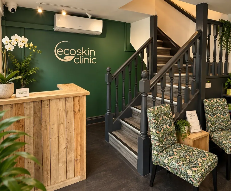 Eco Skin Clinic reception desk, green logo wall and staircase in Walthamstow.
