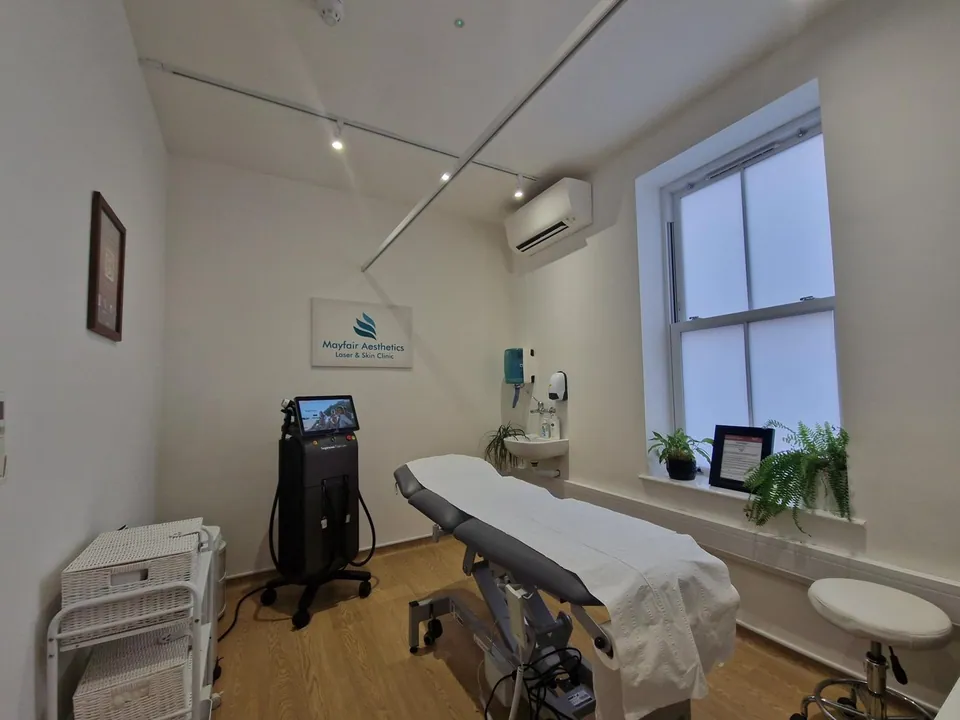 Mayfair Aesthetics Hammersmith treatment room with a couch, sink and laser equipment
