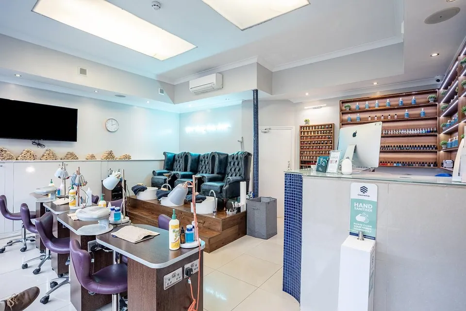 Camden Beauty Spa interior with manicure tables, purple chairs and raised pedicure seats.