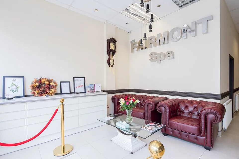 Fairmount Spa reception with a burgundy leather sofa and white reception counter.