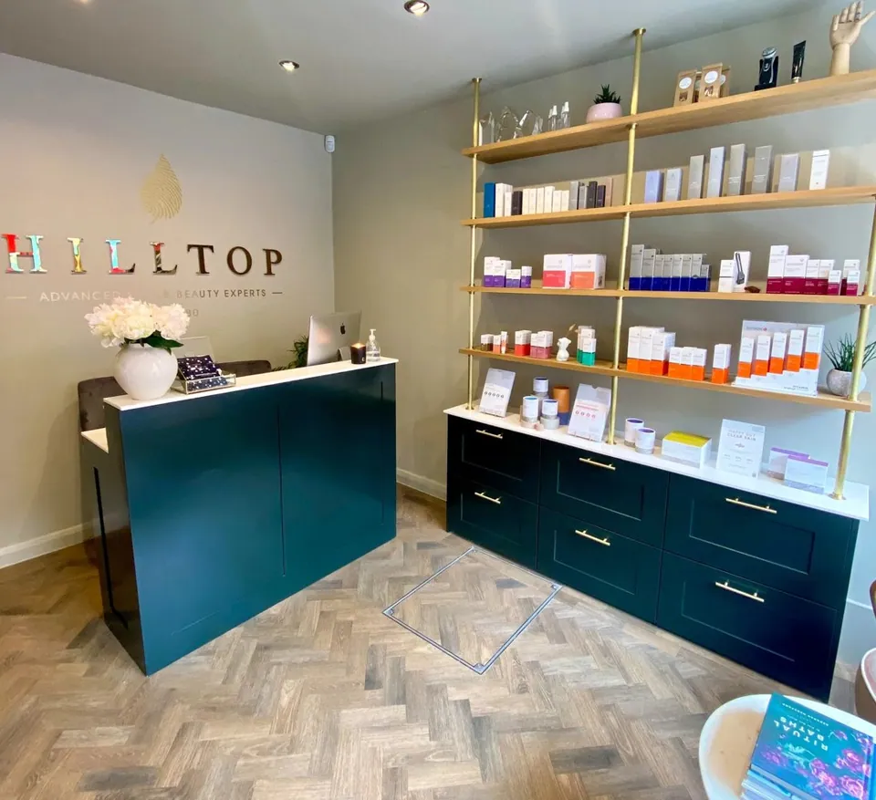 Hilltop reception with a teal desk, product shelves and herringbone floor.