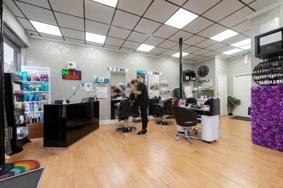 Posh Pro salon interior with styling chairs, product displays and wooden flooring.
