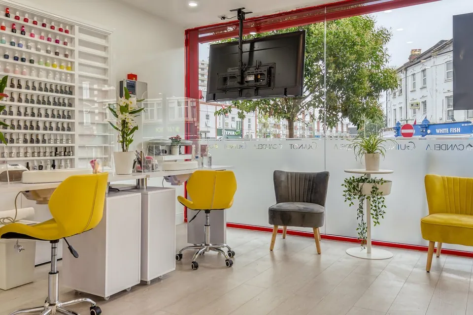 Sunkiss manicure area with yellow chairs, polish shelves and street-facing windows.