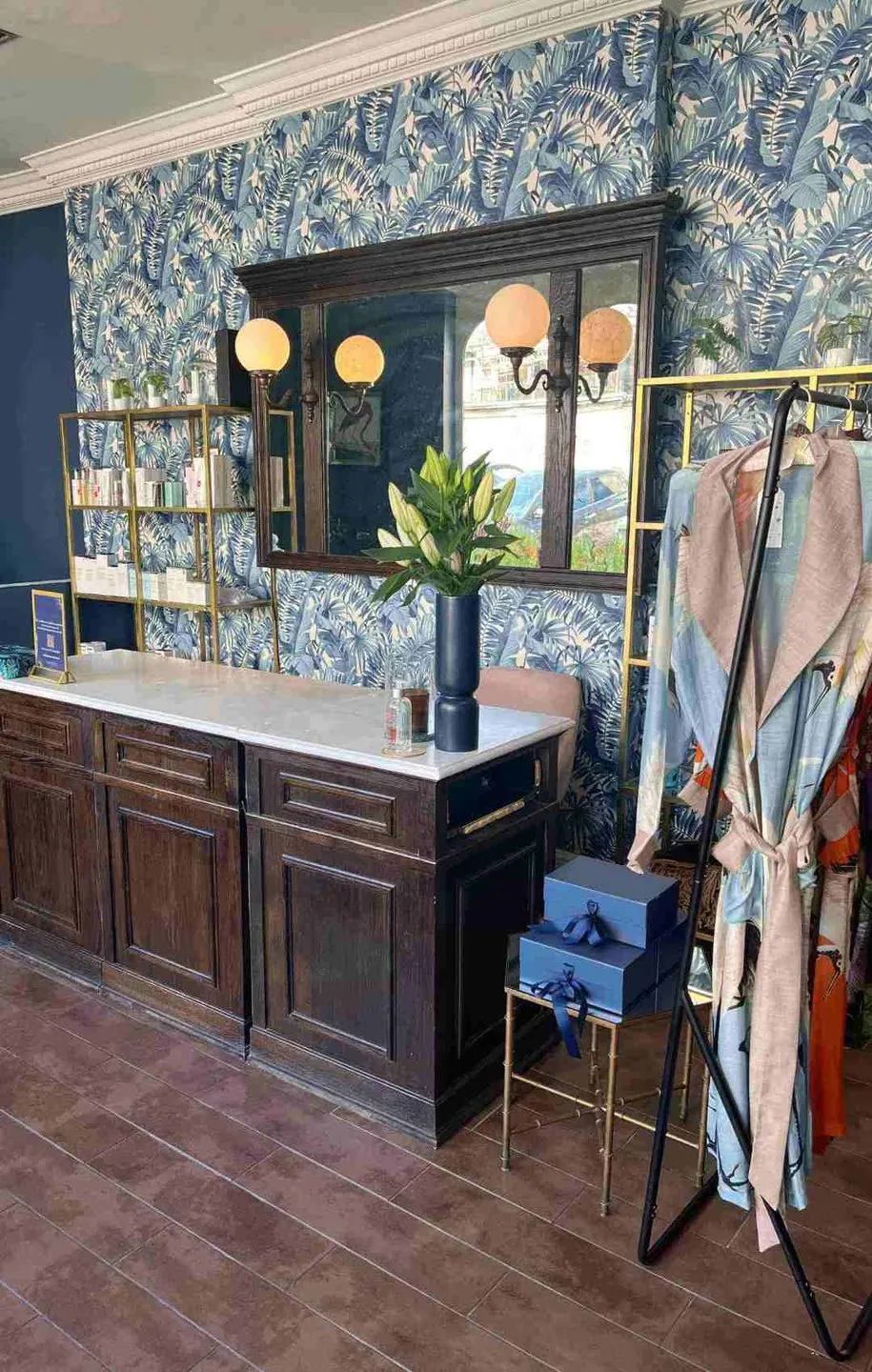 Reception desk, product shelves and patterned wallpaper at Luminis Blackheath.