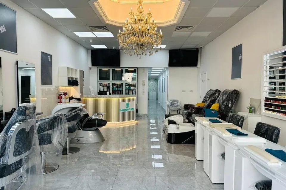 Reception and salon floor beneath a chandelier at Lemoge Cricklewood