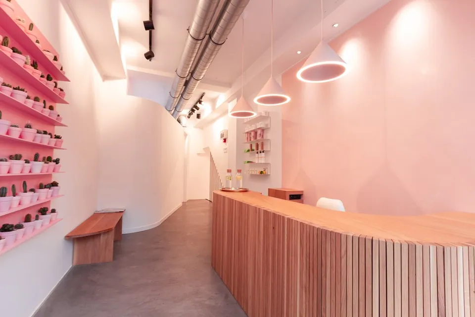 Shoreditch reception with a wooden desk and pink pendant lights
